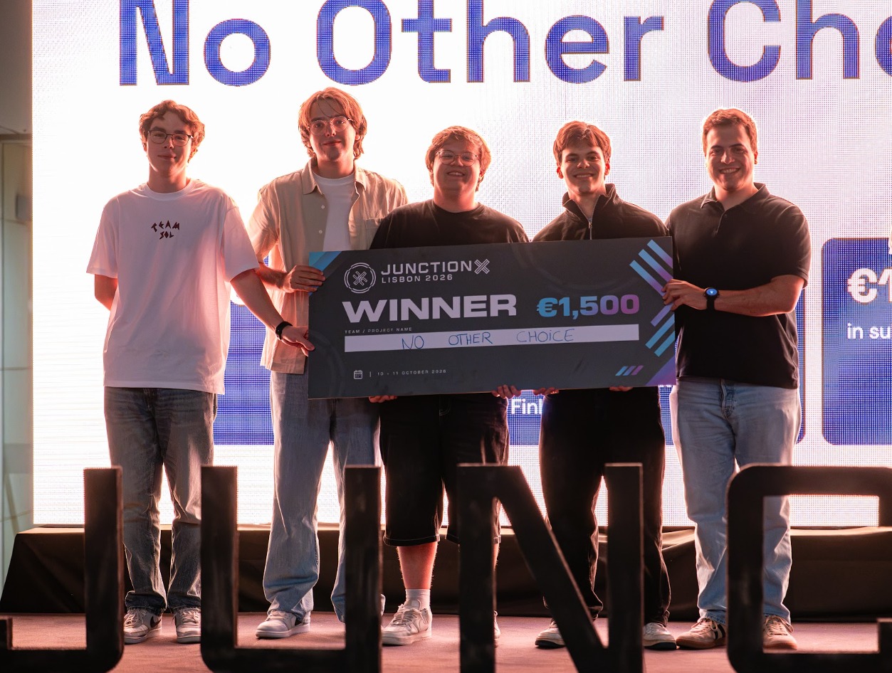 The five members of No Other Choice smiling on stage at JunctionX Lisbon 2026, holding the winner's cheque for €1,500.